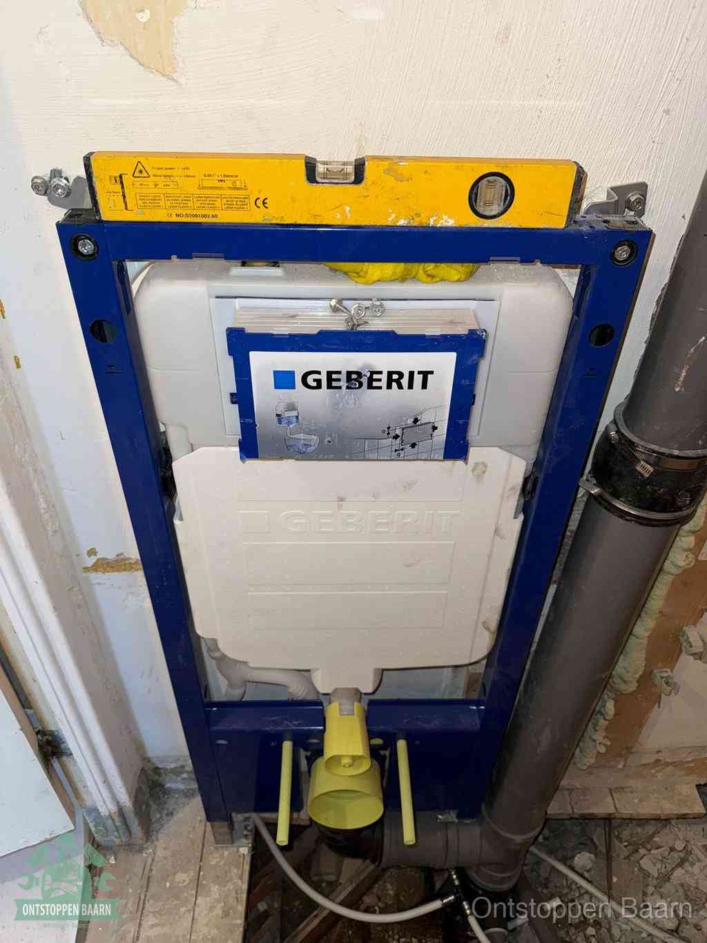 Een Geberit inbouwreservoir met frame voor een hangtoilet tegen de wand, met de afvoerbocht naar de vloer, kenmerkend voor een verstopt hangtoilet in Baarn