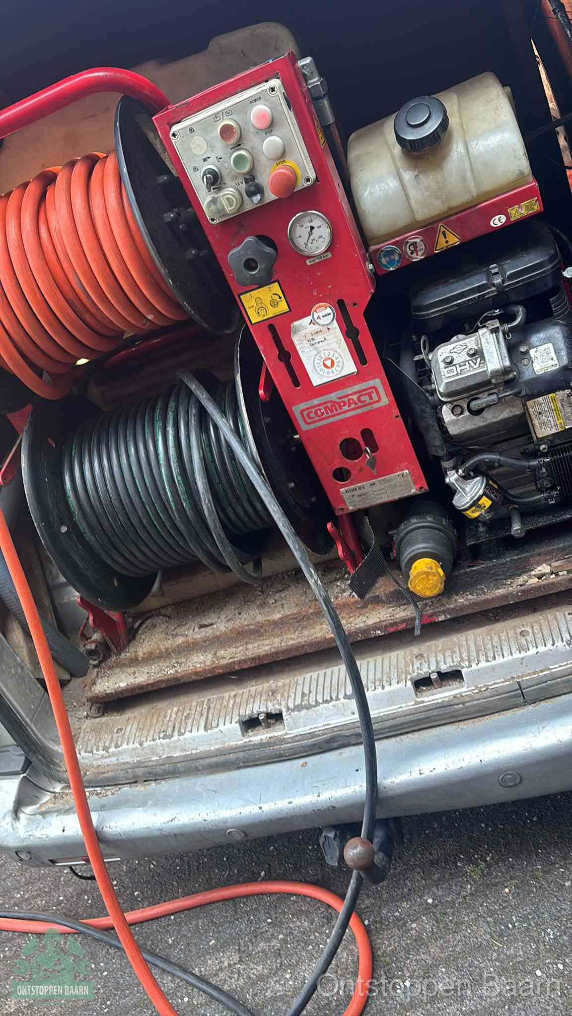 Een rood hogedruk-rioolreinigingstoestel met slangen in de laadbak van de bedrijfsbus, apparatuur voor een hardnekkige wc-verstopping in Baarn