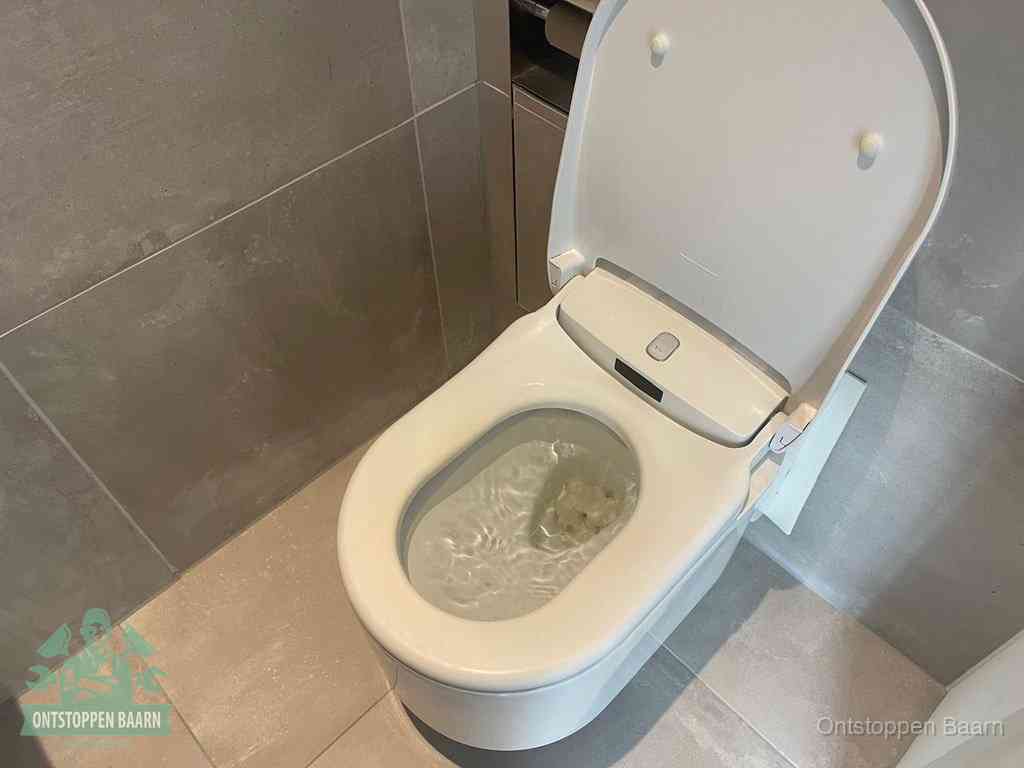 Een toiletpot vol troebel water met drijvend papier en restanten, de meest voorkomende oorzaak van een verstopte wc in Baarn