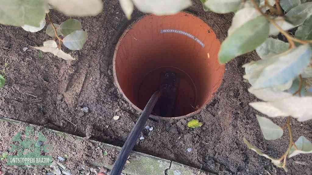 Open inspectieput in de tuin waar een veer rioolvliegjes en stankoverlast aanpakt in Baarn