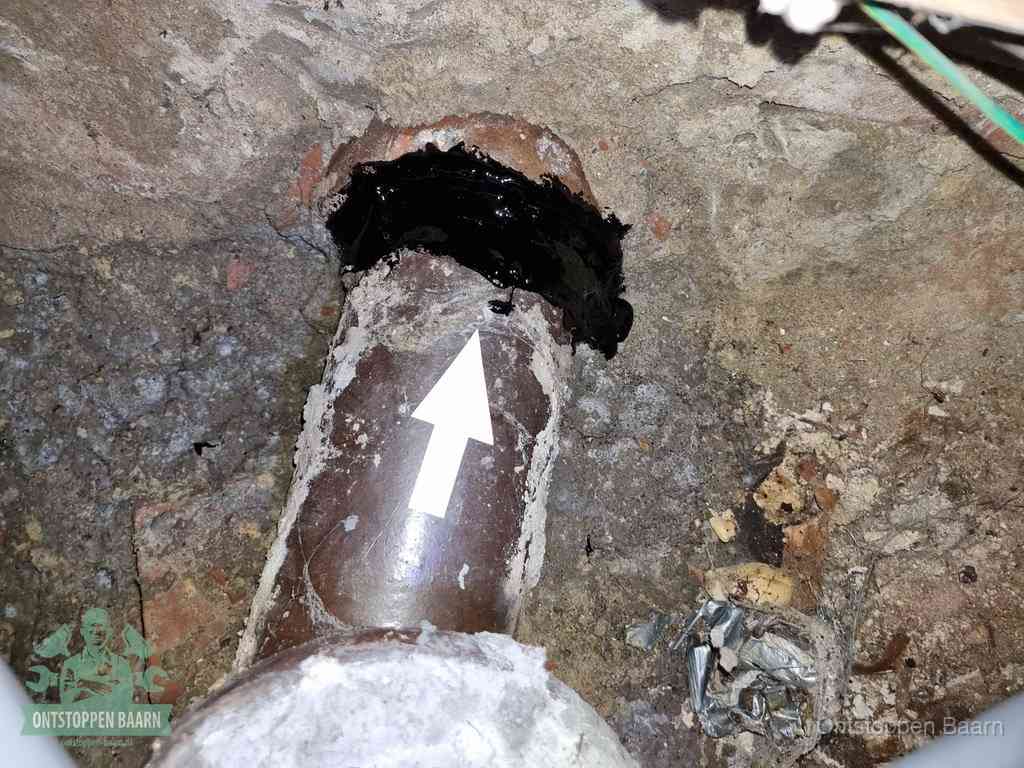 Een oude gres rioolbuis met een beschadigde koppeling onder de vloer, oorzaak van terugkerende structurele wc-problemen in Baarn