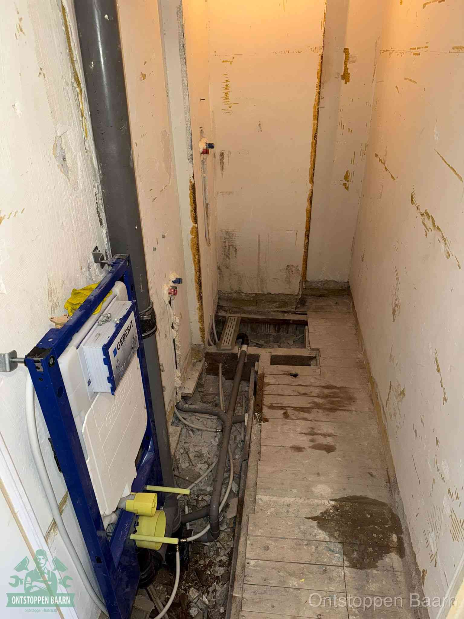 Een opgebroken toiletruimte tijdens renovatie met een Geberit inbouwreservoir en blootliggende oude afvoerleidingen, typisch voor oudere woningen in Baarn